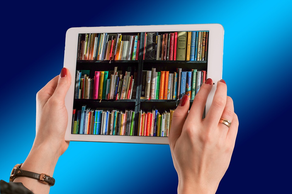 iPad default graphic showing someone holding an ipad with a photo of books on the screen
