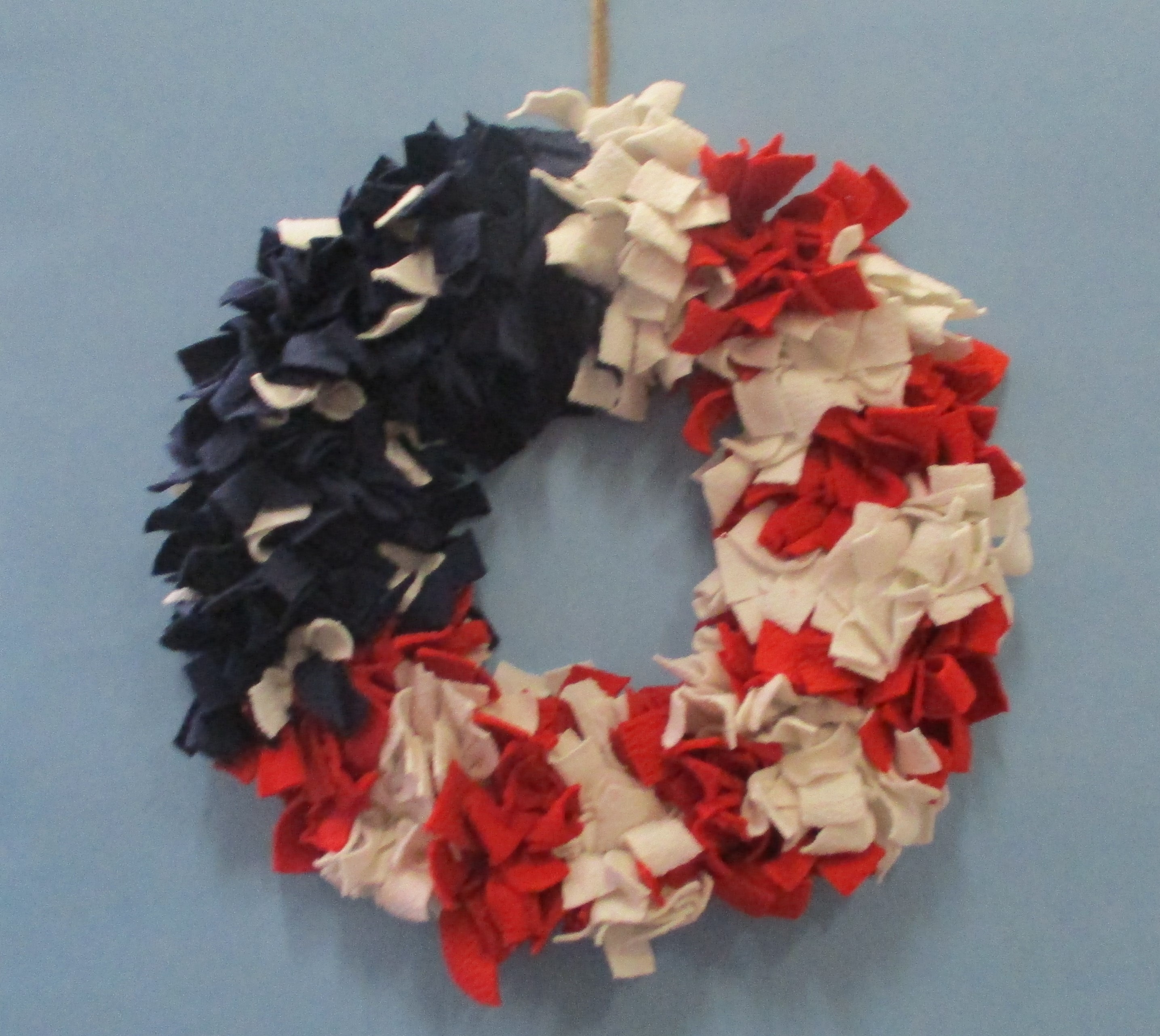 Strips of red, white, and blue fabric used to make a patriotic wreath.