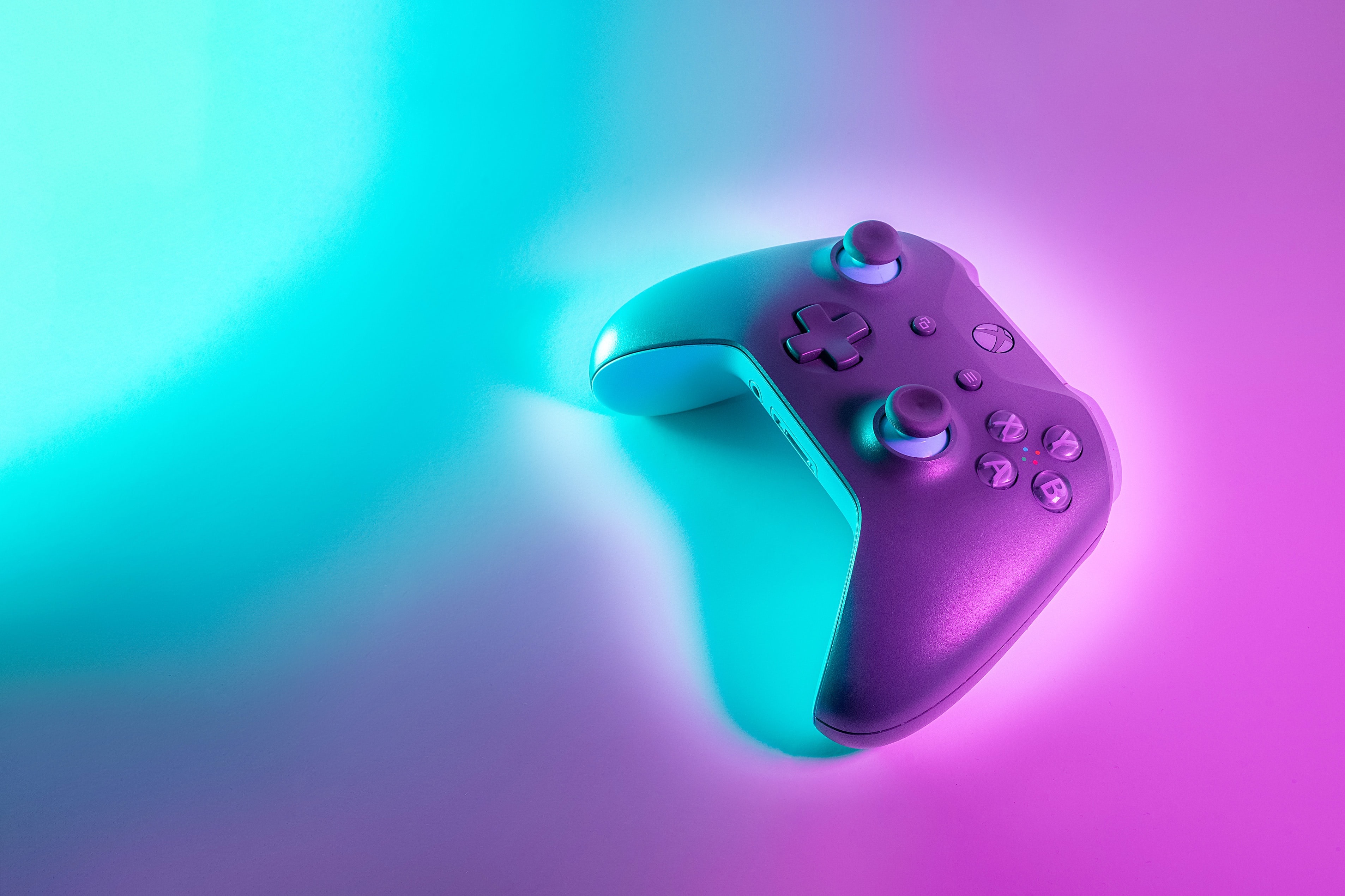 x-box controller on a cool teal and pink background
