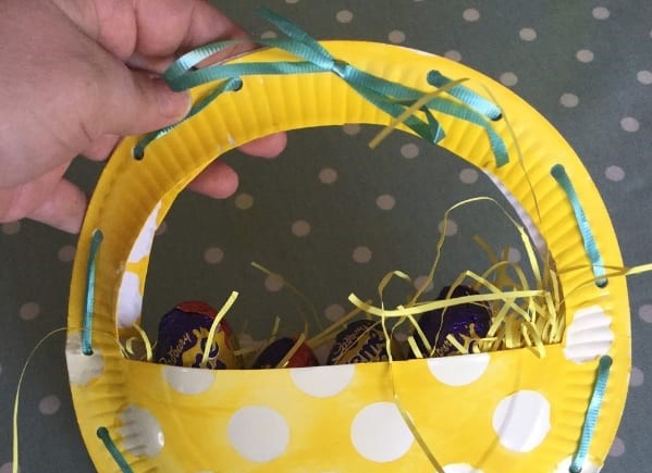 Easter basket made out of paper plates with Cadbury eggs inside.
