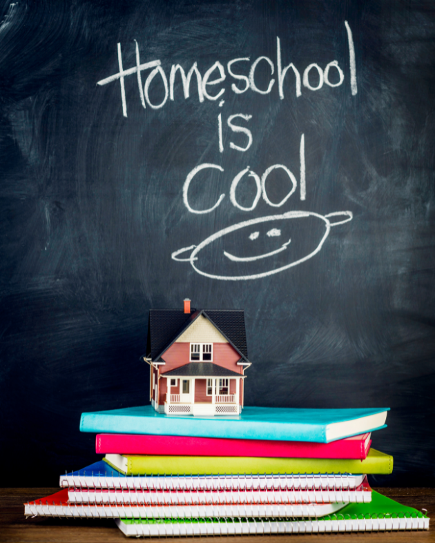 Blackboard with the words Homeschool is Cool written in  chalk  and a tiny house sitting on top of a stack of notebooks on top of a wooden surface.