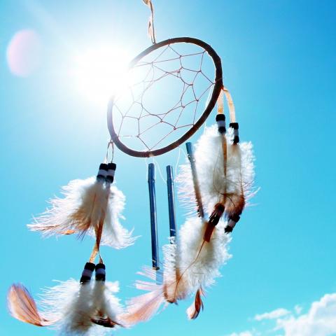 Photo of a dream catcher with a blue sky background.