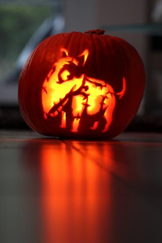 Pumpkin with a zombie dog carved into it.