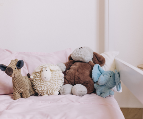 Stuffed Animals in a childs bed.