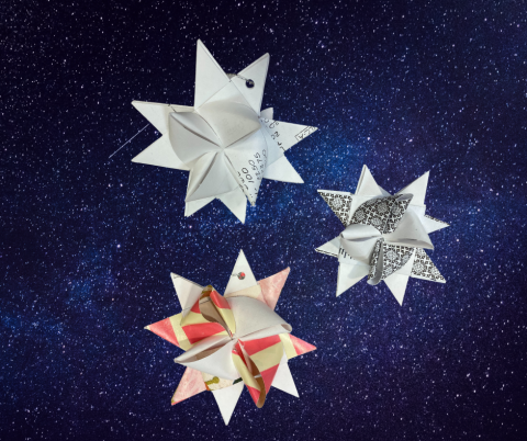 Paper stars overlaid on top of a photo of the night sky.