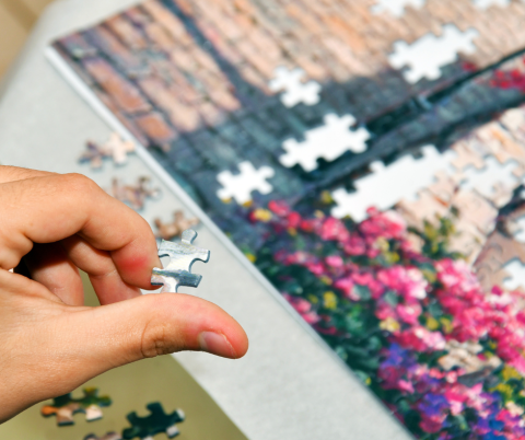 Person putting together a Jigsaw.