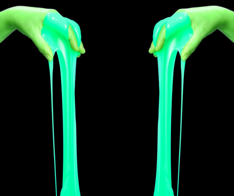 Hands dripping with glow in the dark slime.