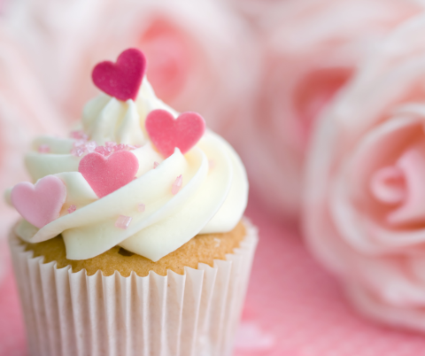 Cupcake with Hearts and pink roses in the background.