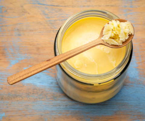 Butter in a jar with a wooden spoon