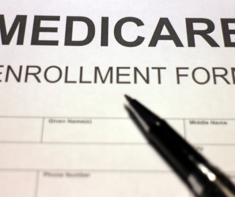 Medicare Enrollment Form and a black pen.