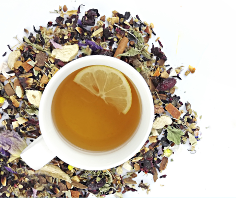 Cup of herbal tea surrounded by the tea blend.