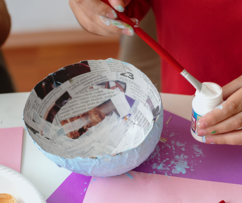 Person making a paper mache bowl