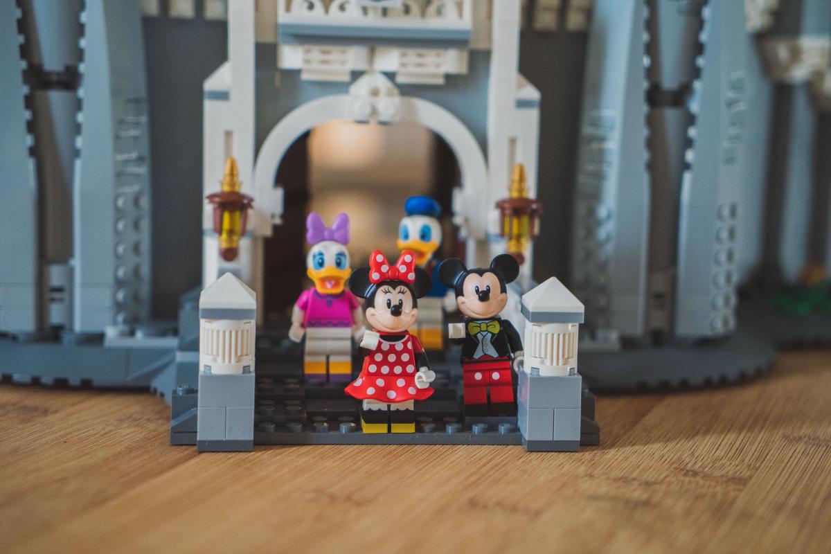 Lego Minnie, Mickey, Donald and Daisy Duck in front of a Lego Castle.