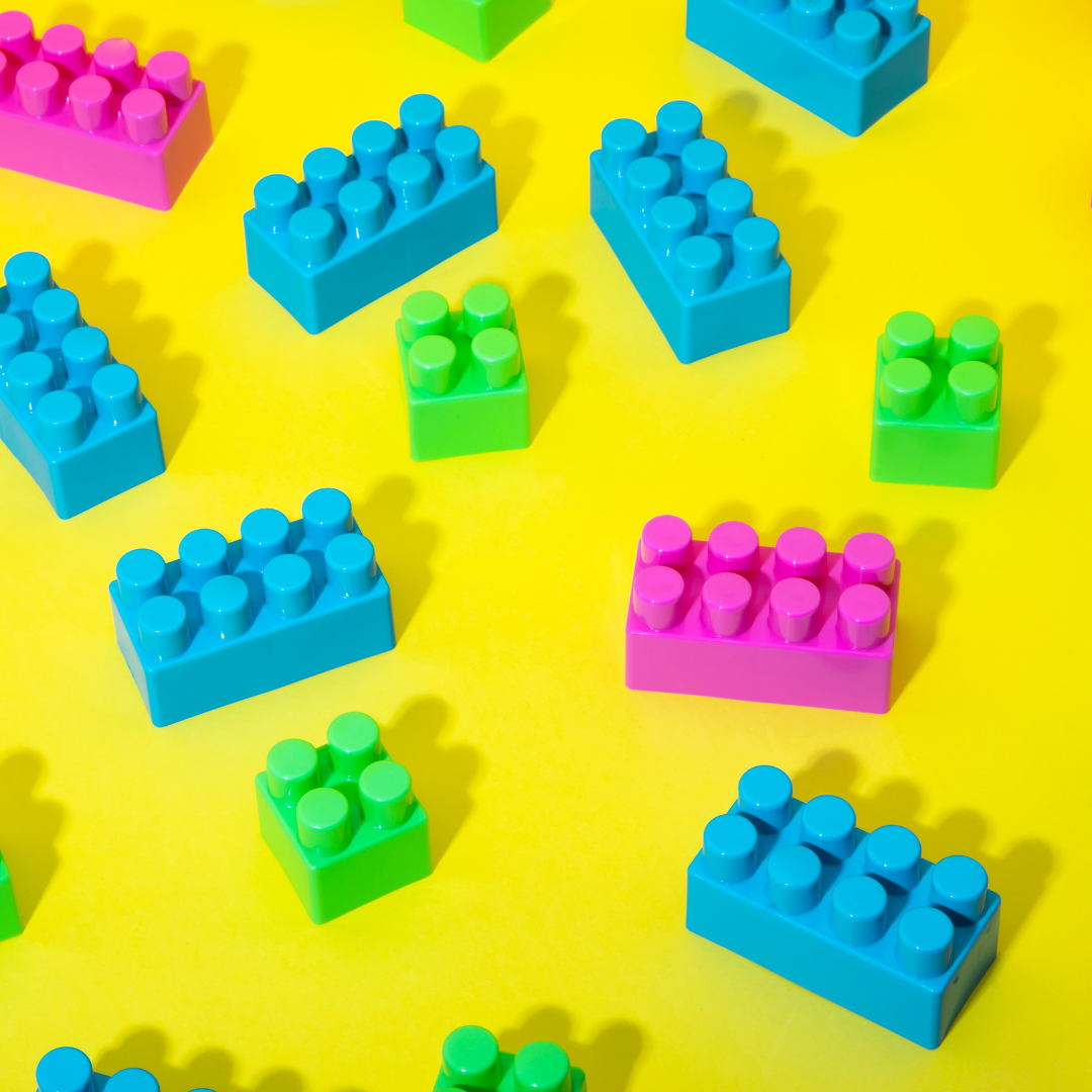 Neon Legos on a yellow background.