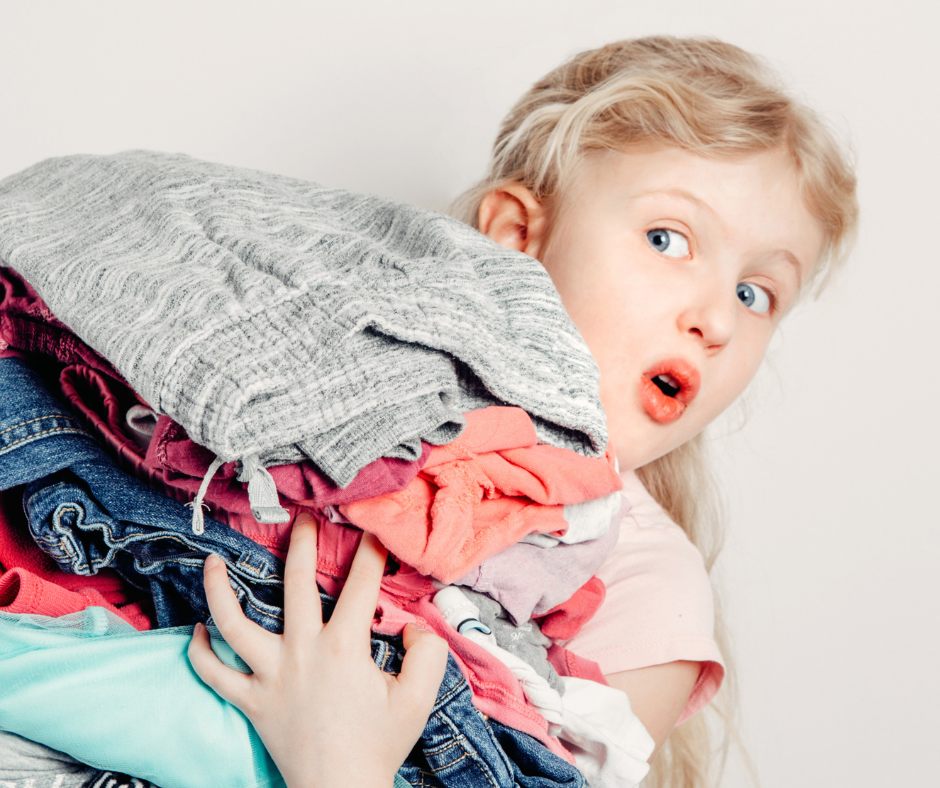 Blonde girl holding a pile of clothing