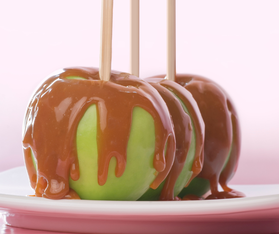 Caramel drizzled over green apples on sticks