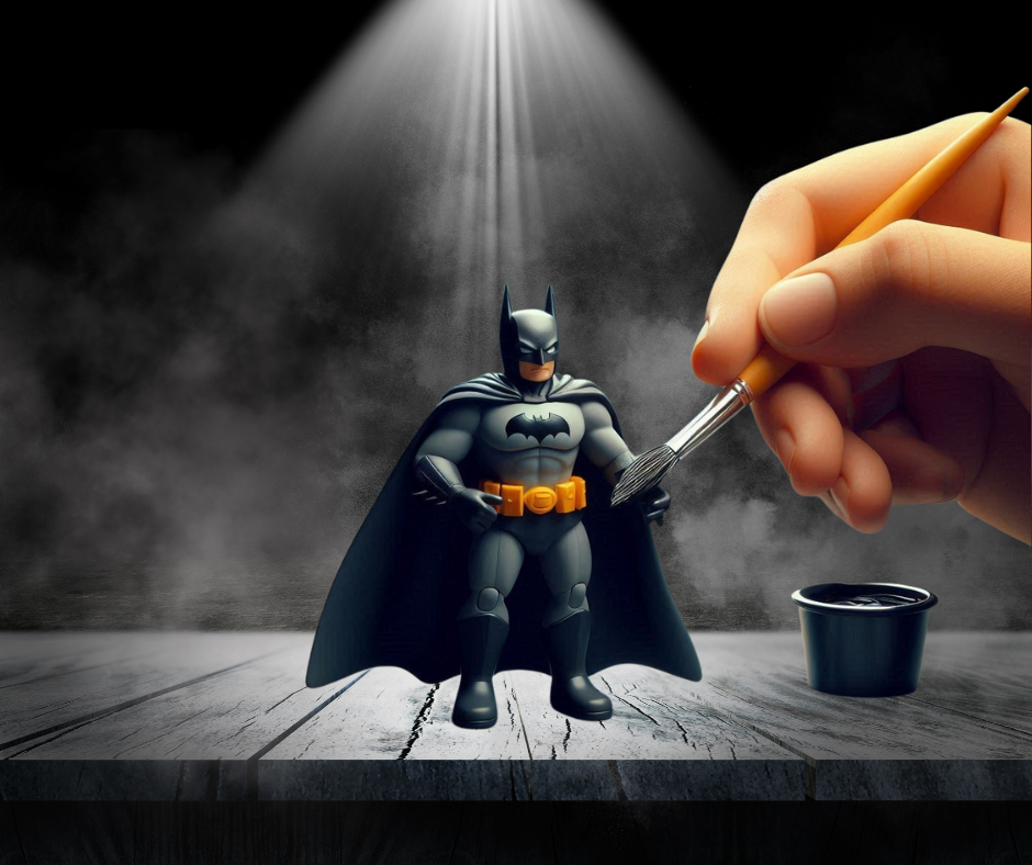 Hand painting a miniature Batman in a dark spotlight room.