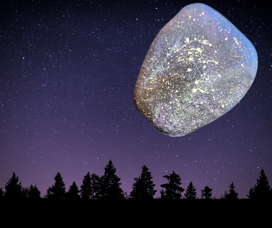 Rock painted like the night sky superimposed over a photo of the night sky and trees.